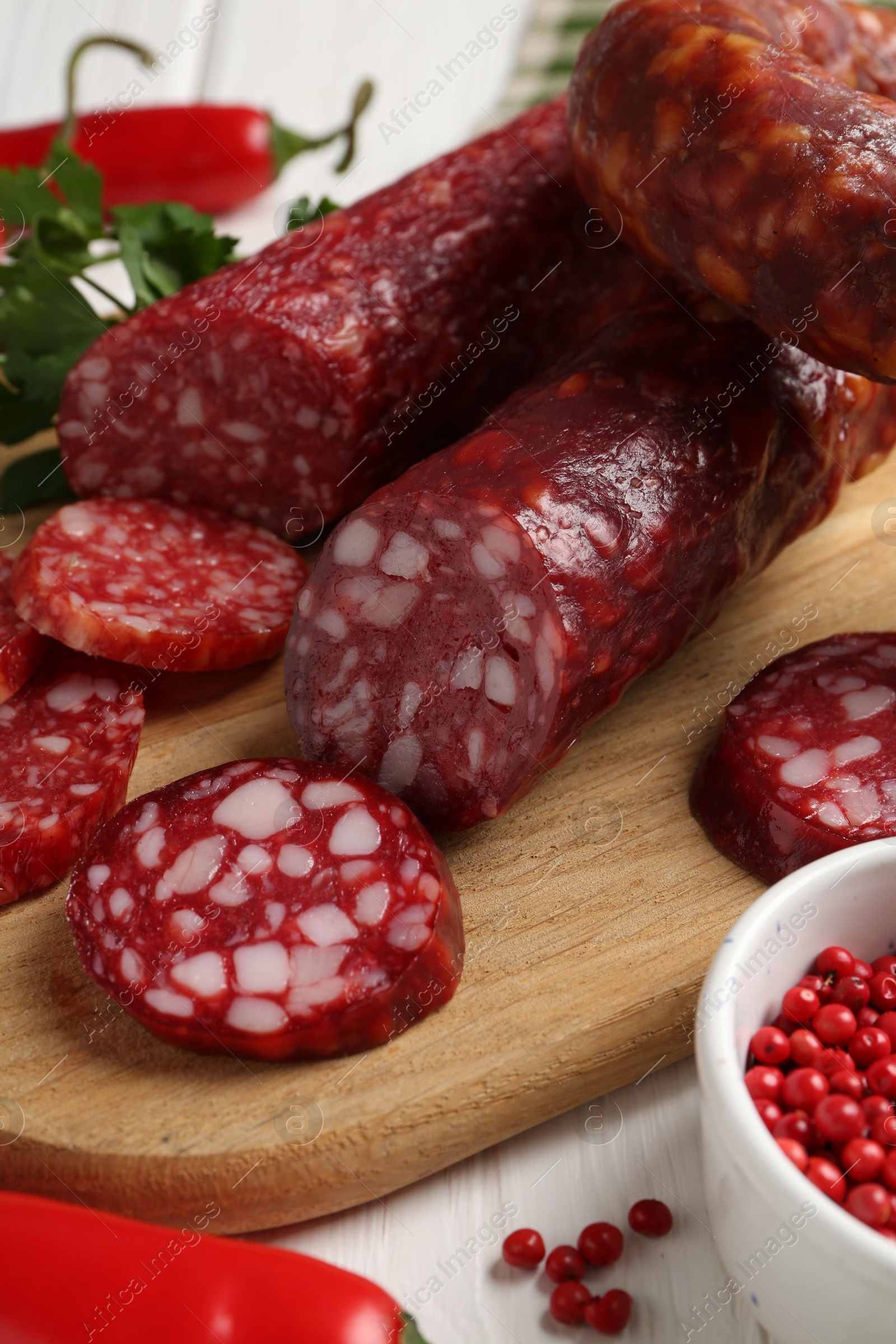 Photo of Different smoked sausages and spices on table, closeup