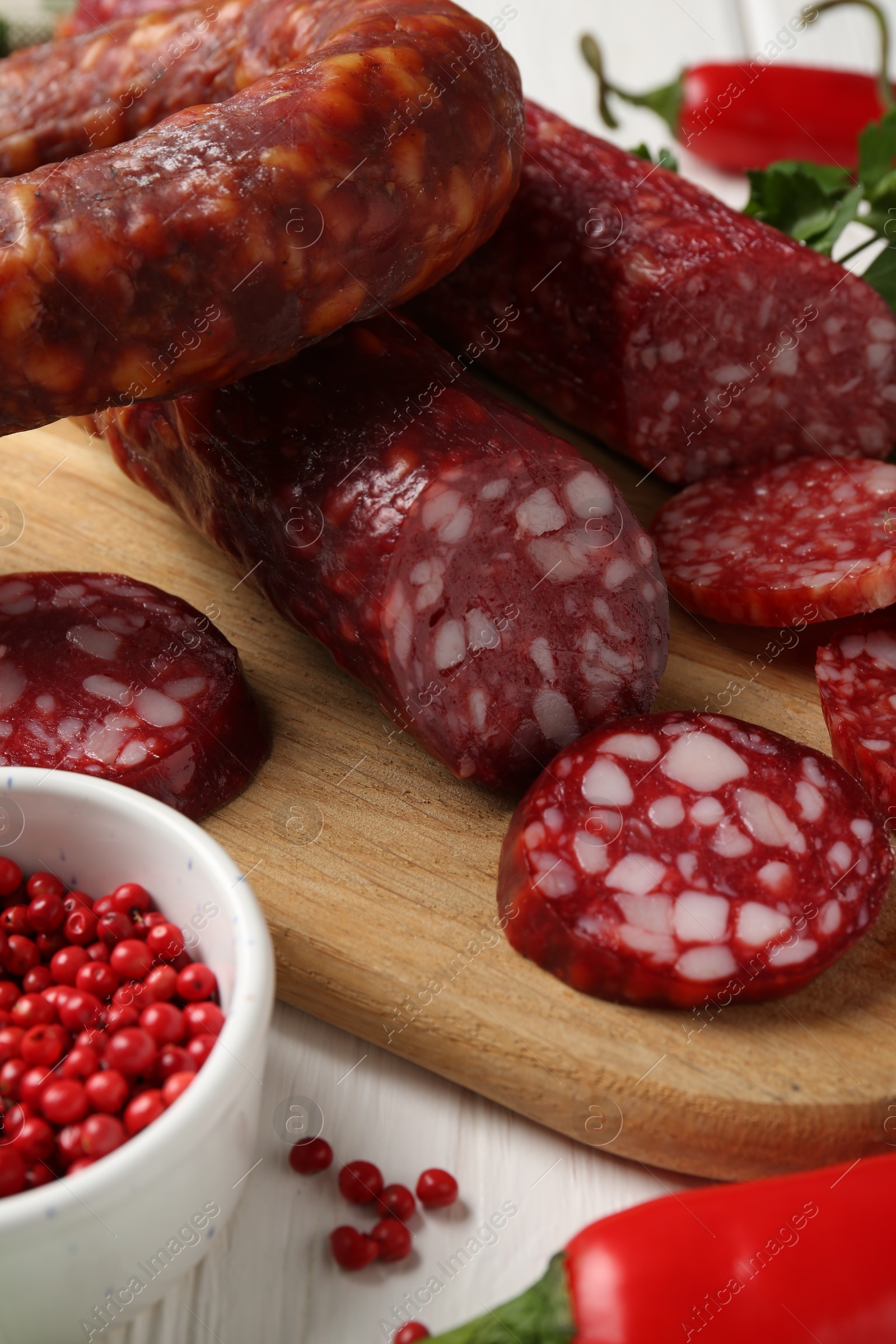 Photo of Different smoked sausages and spices on table, closeup