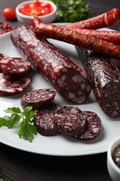 Photo of Different smoked sausages and spices on table, closeup