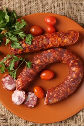 Photo of Different smoked sausages, cherry tomatoes and parsley on table, top view