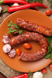 Photo of Different smoked sausages, cherry tomatoes and spices on table, flat lay