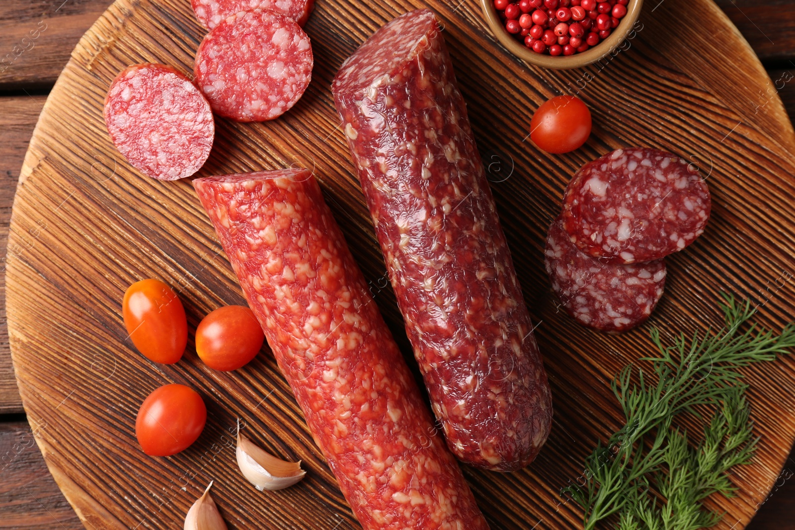 Photo of Different smoked sausages, cherry tomatoes and spices on table, top view