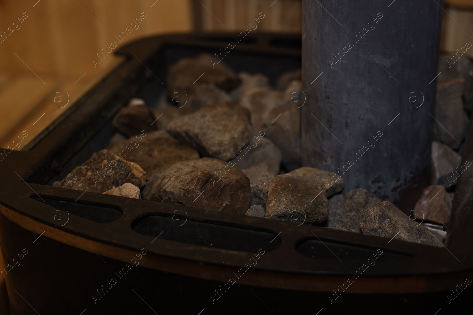 Photo of Stove with hot rocks in sauna, closeup