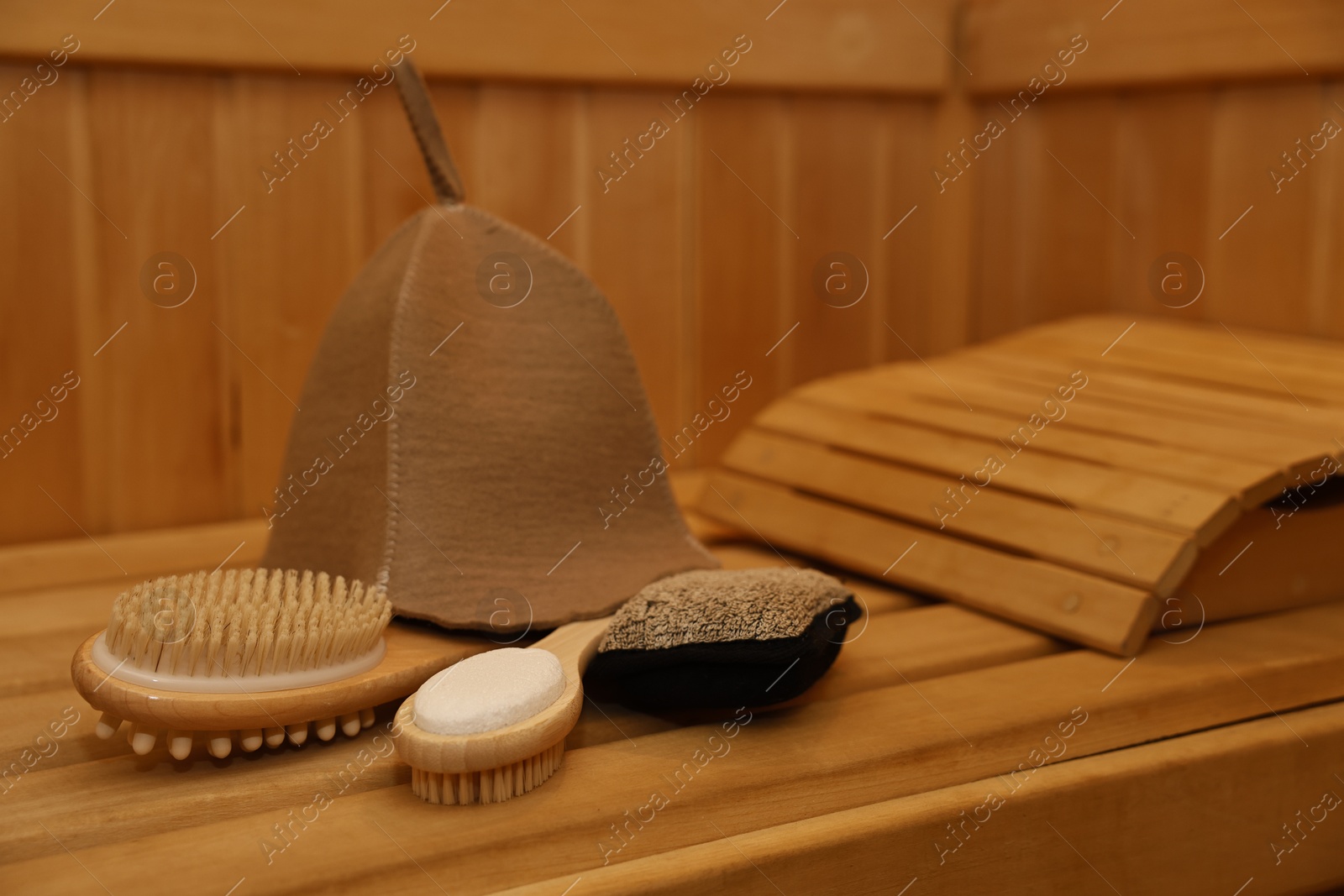 Photo of Felt wool hat and bath accessories on wooden bench in sauna