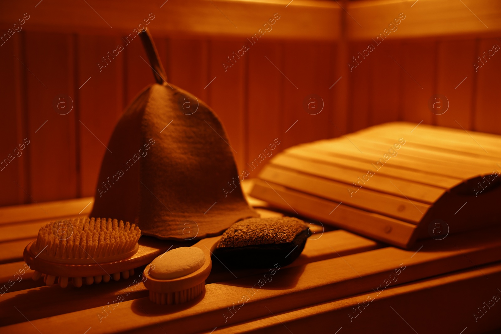 Photo of Felt wool hat and bath accessories on wooden bench in sauna