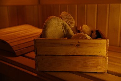 Photo of Crate with bath accessories on bench in sauna