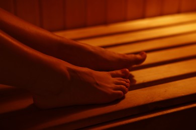 Young woman relaxing in hot sauna, closeup