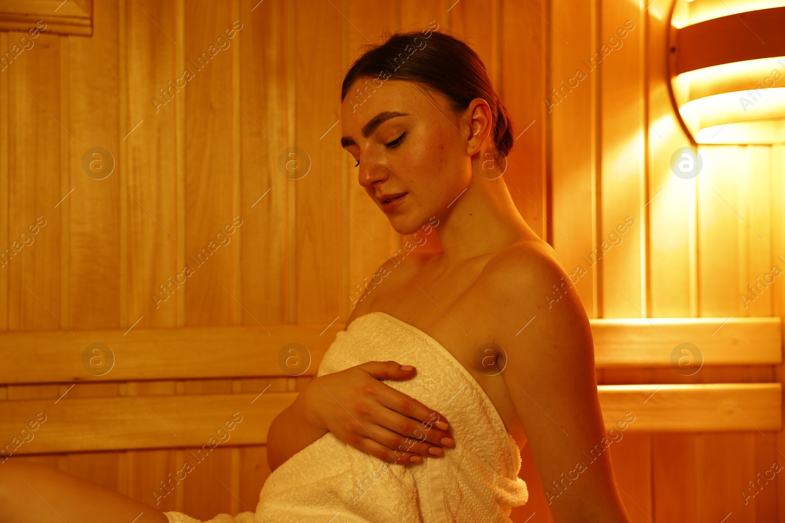 Photo of Beautiful woman wrapped in towel at sauna