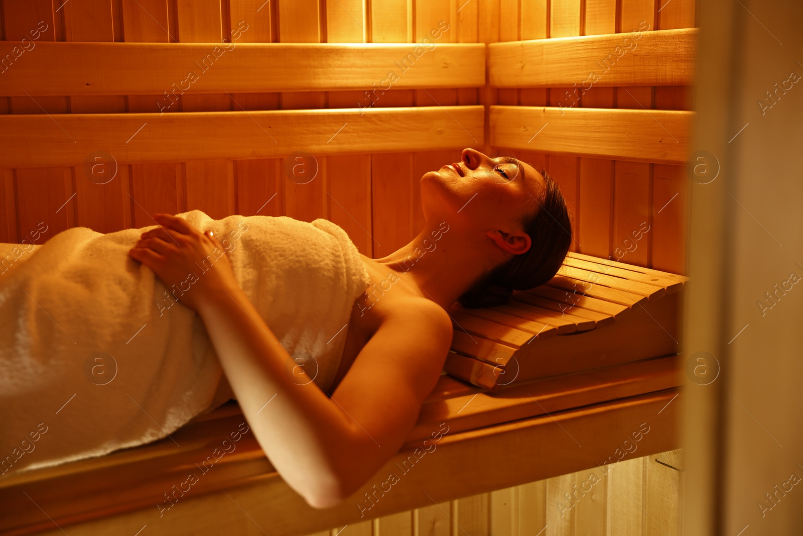 Photo of Beautiful woman relaxing on bench in sauna