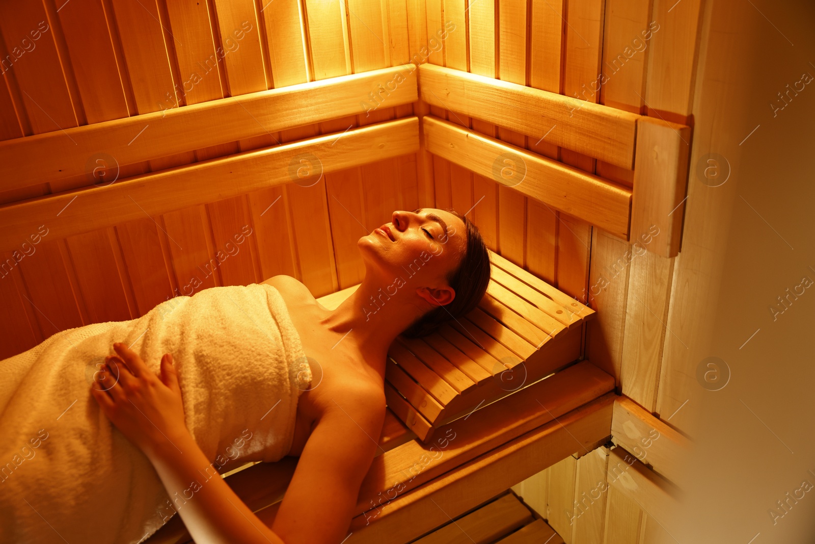 Photo of Beautiful woman relaxing on bench in sauna