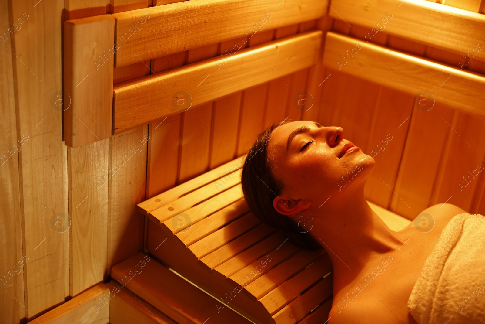 Photo of Beautiful woman relaxing on bench in sauna