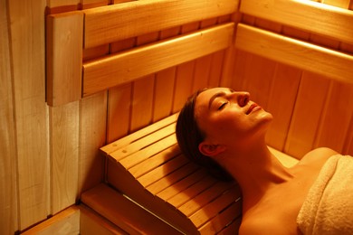 Photo of Beautiful woman relaxing on bench in sauna