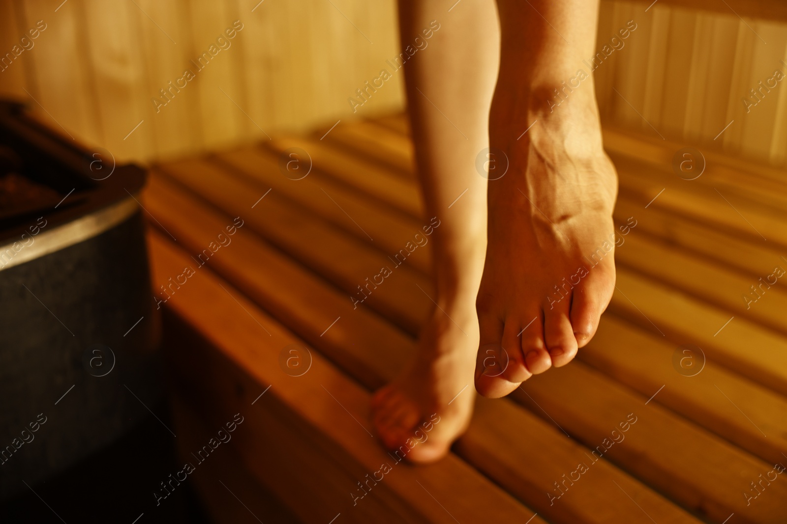 Photo of Young woman relaxing in hot sauna, closeup. Space for text