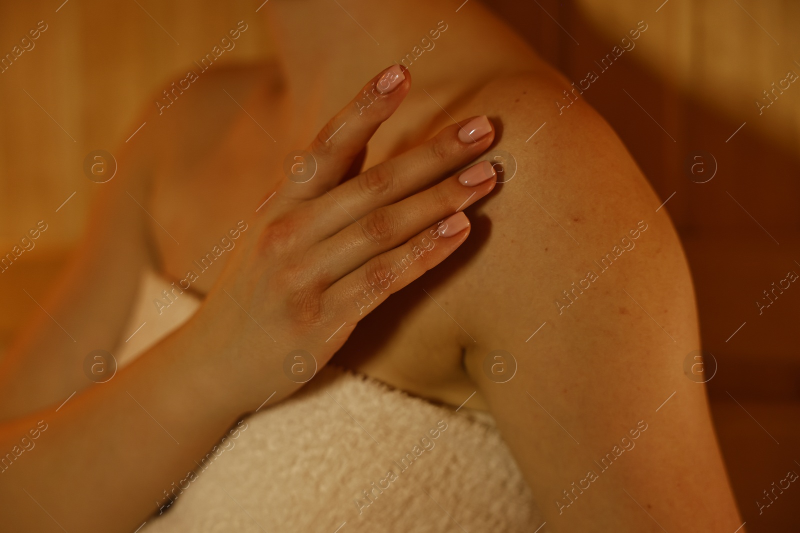 Photo of Young woman relaxing in hot sauna, closeup