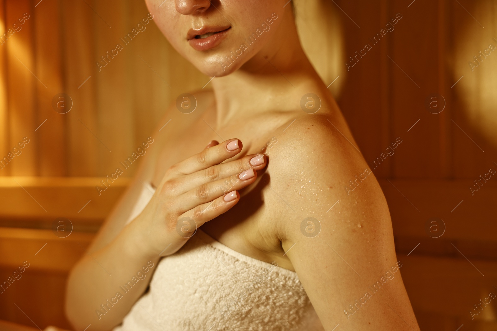 Photo of Young woman relaxing in hot sauna, closeup