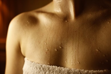 Photo of Young woman relaxing in hot sauna, closeup