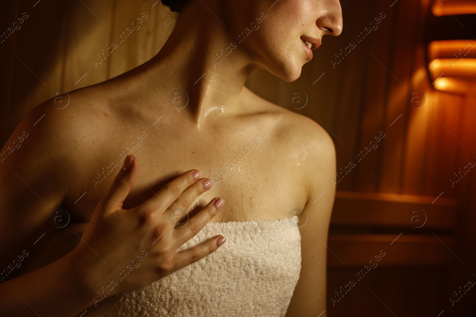 Photo of Young woman relaxing in hot sauna, closeup