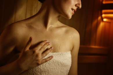 Photo of Young woman relaxing in hot sauna, closeup