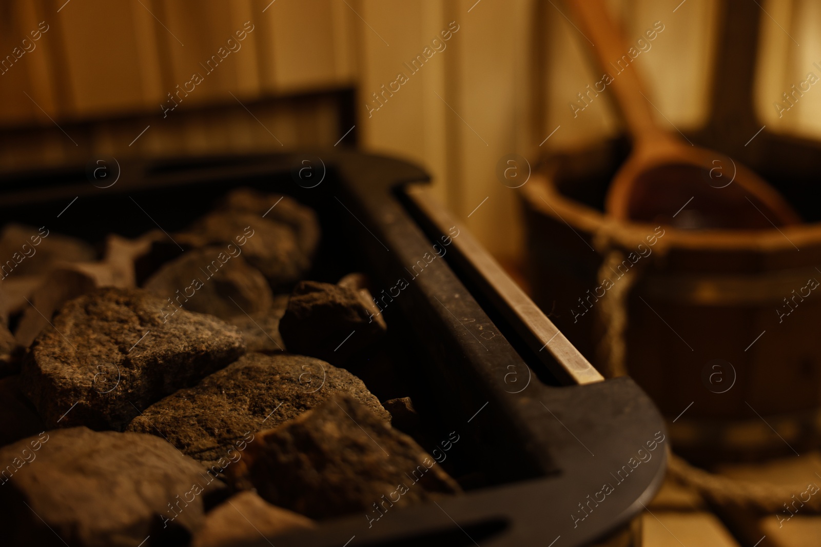 Photo of Stove with hot rocks in sauna, closeup