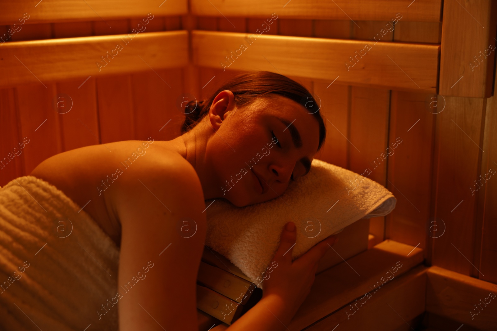 Photo of Beautiful woman lying on bench in sauna