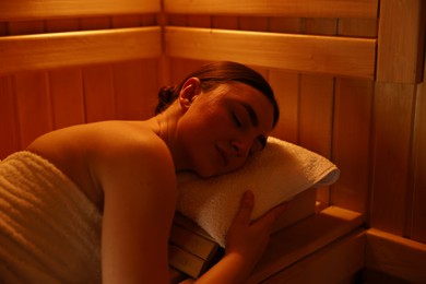 Photo of Beautiful woman lying on bench in sauna