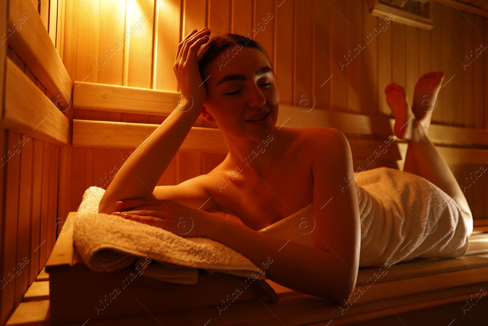 Photo of Beautiful woman lying on bench in sauna