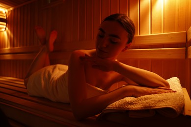 Photo of Beautiful woman lying on bench in sauna