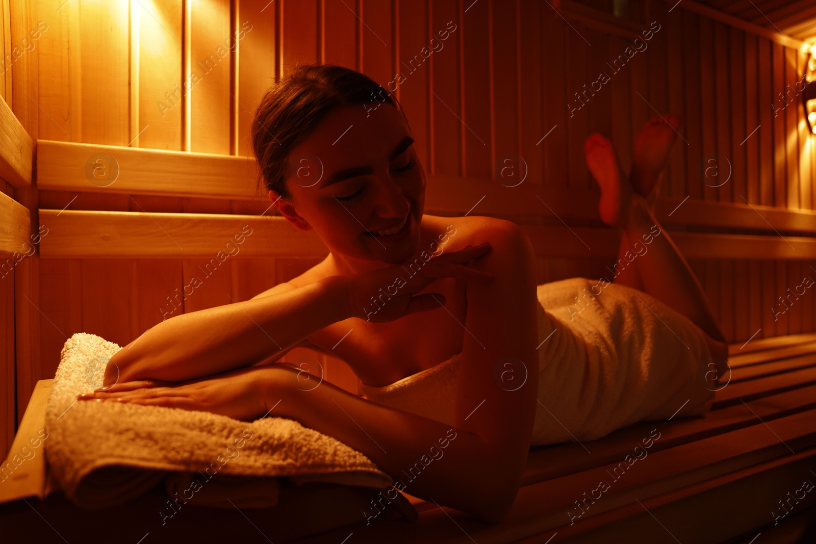 Photo of Beautiful woman lying on bench in sauna