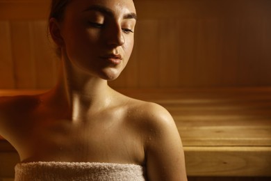 Photo of Beautiful woman relaxing in hot sauna, closeup. Space for text