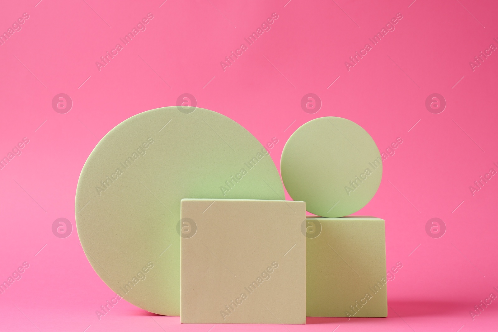 Photo of Presentation of product. Light green podiums on pink background