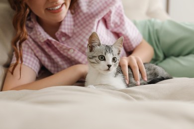 Photo of Teenage girl with cute cat on sofa at home, closeup