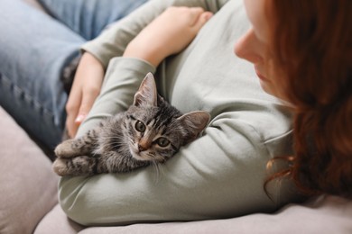 Photo of Teenage girl with cute cat on sofa at home, closeup