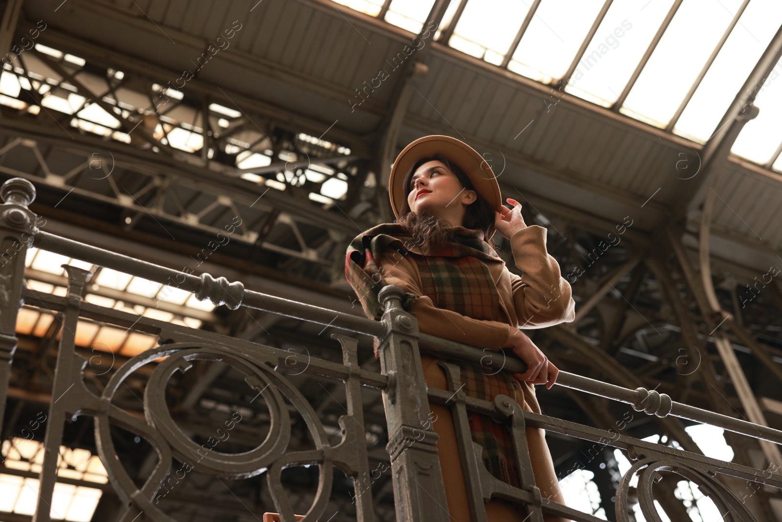 Photo of Beautiful woman in hat at railway station, low angle view