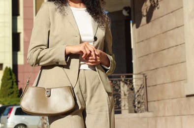 Photo of Young woman wearing stylish suit outdoors, closeup