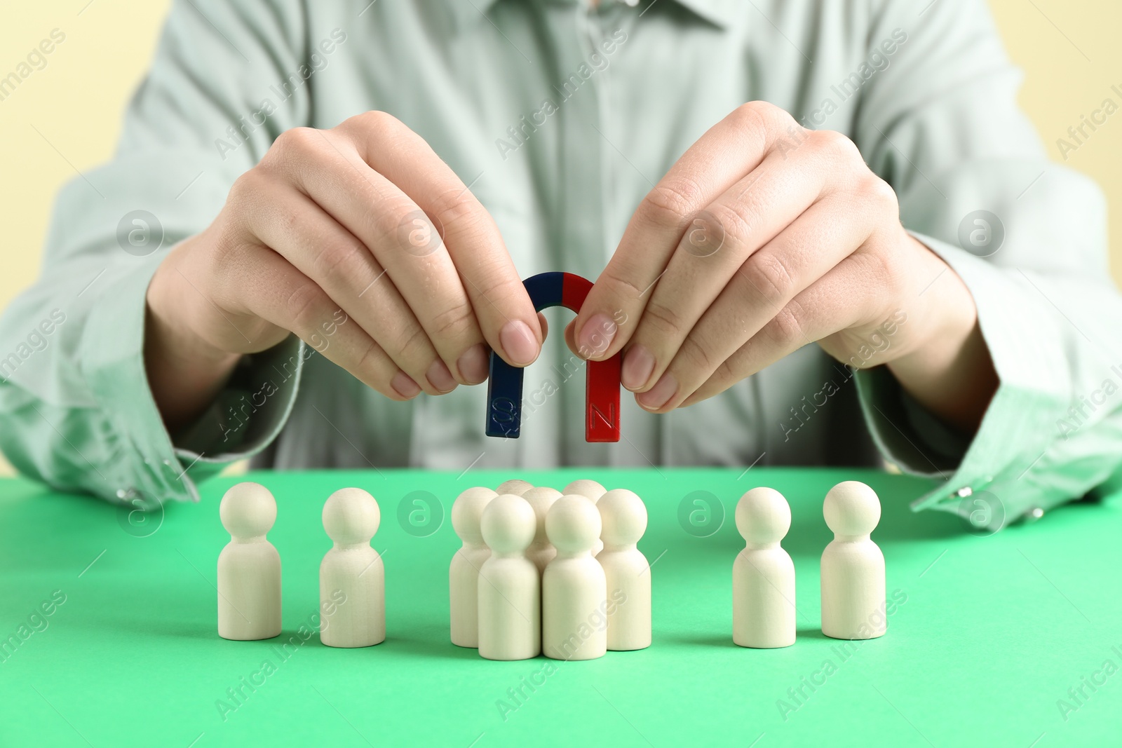 Photo of Woman with magnet attracting game pieces at green table, closeup