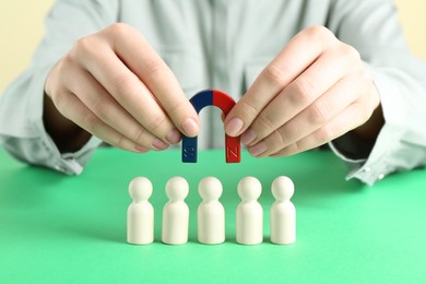 Photo of Woman with magnet attracting game pieces at green table, closeup