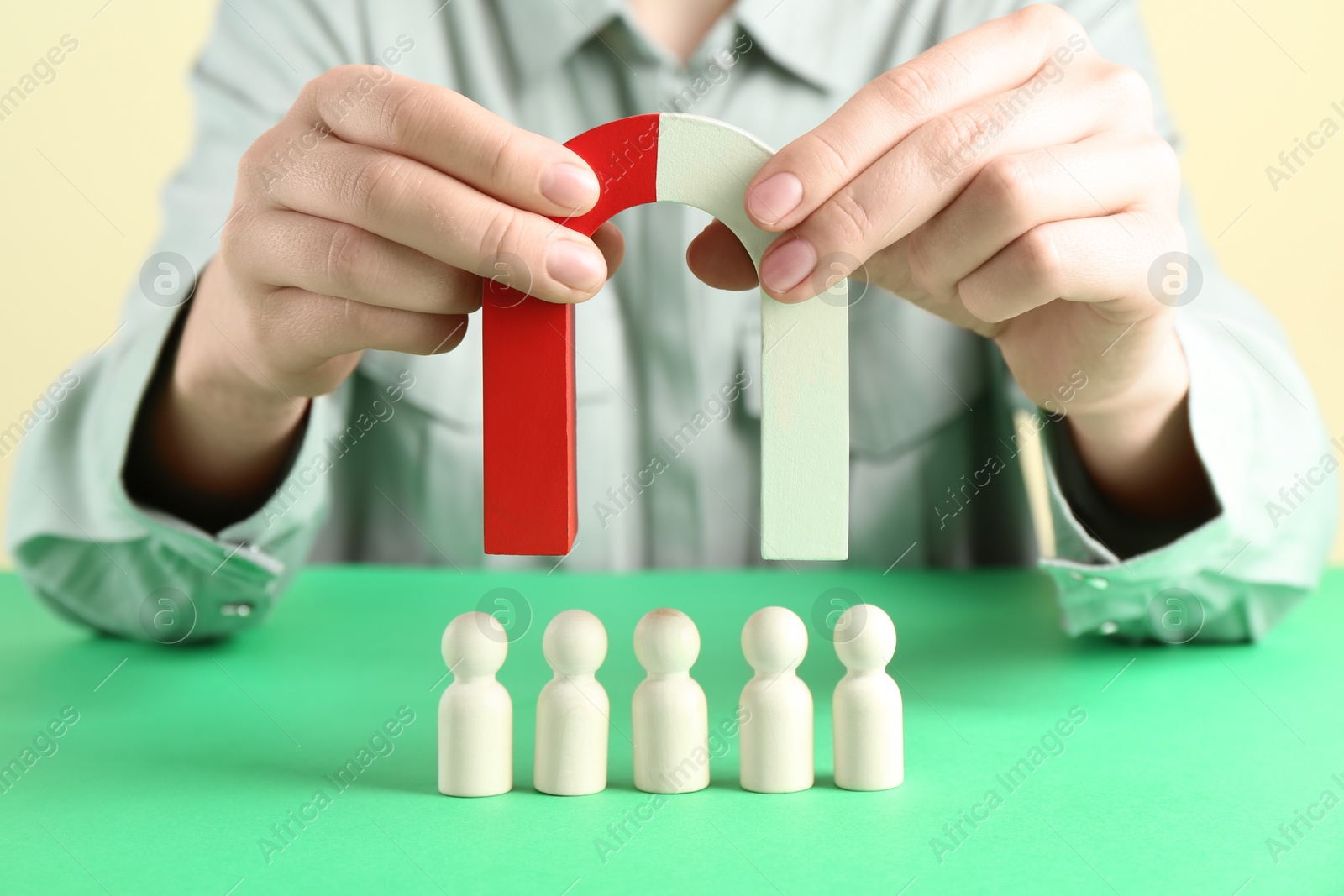 Photo of Woman with magnet attracting game pieces at green table, closeup