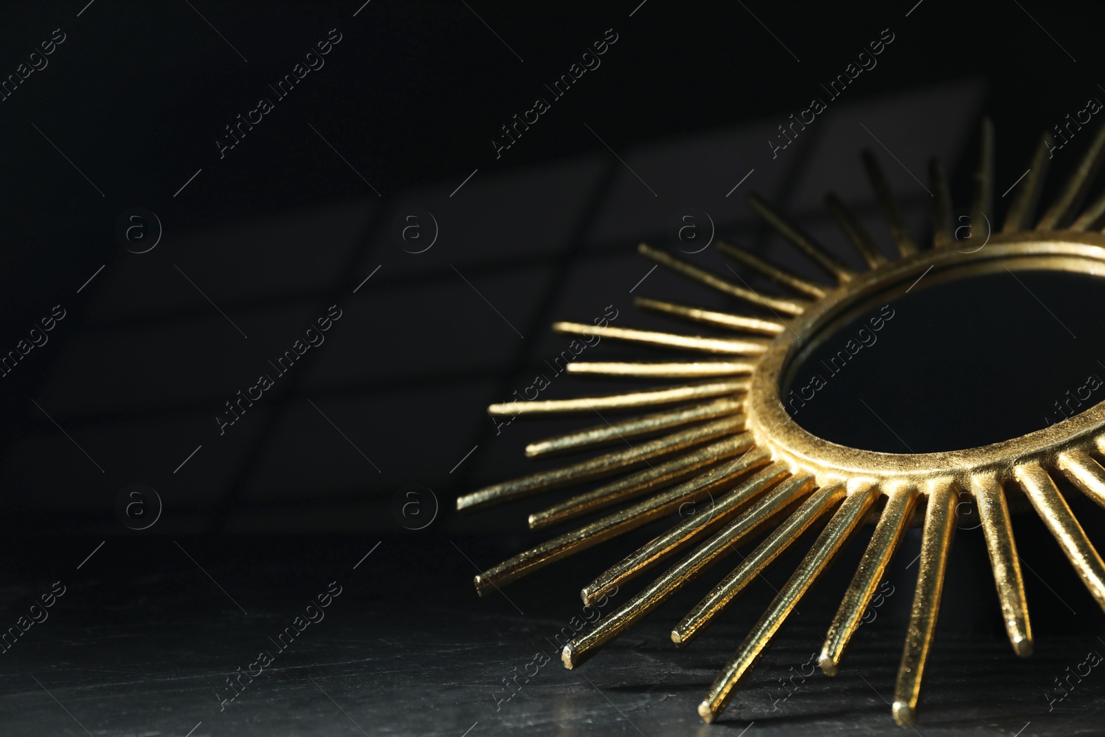 Photo of Stylish golden decor on black background, closeup. Space for text