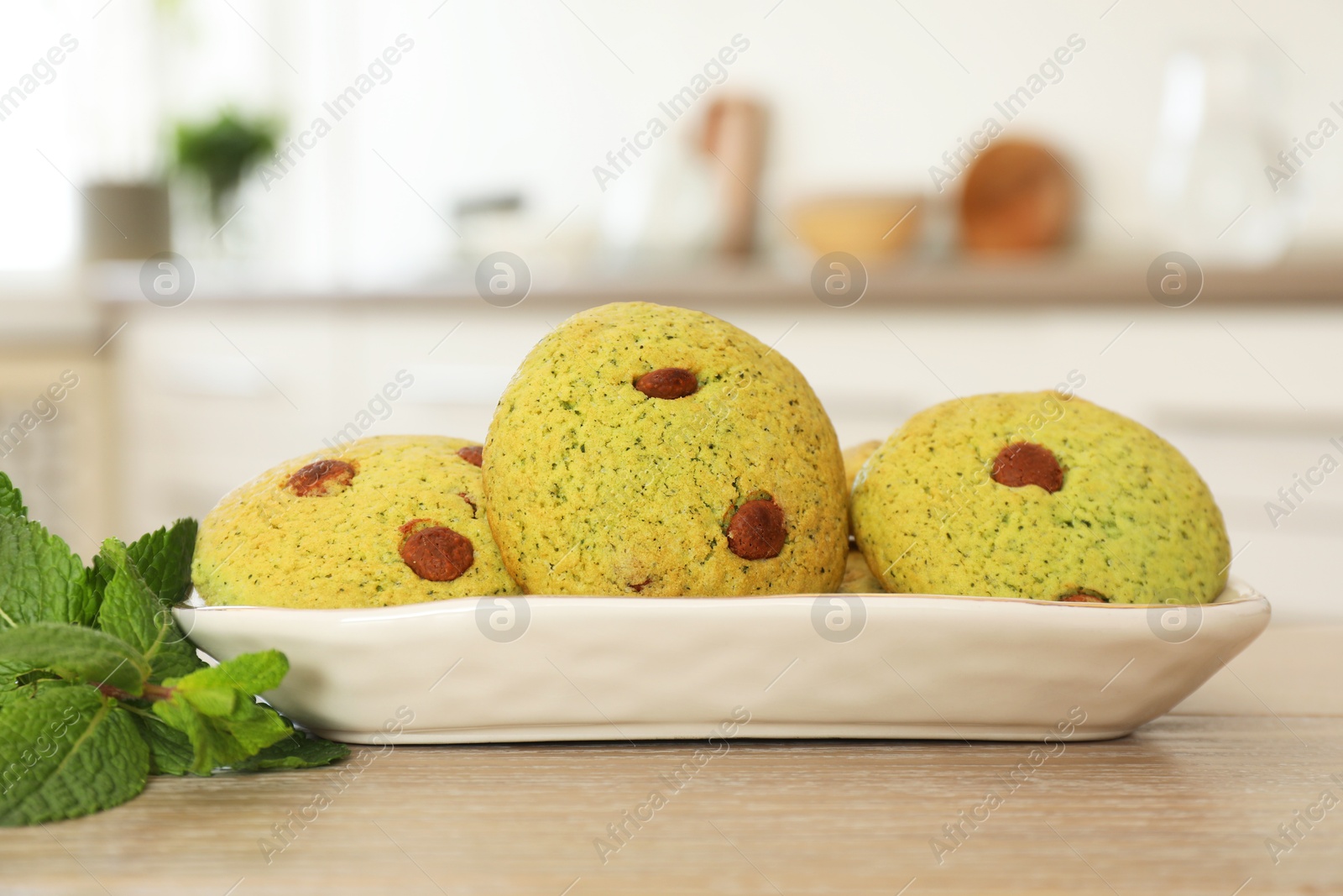 Photo of Delicious mint chocolate chip cookies on wooden table, closeup