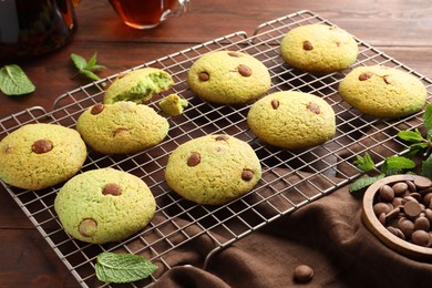 Photo of Delicious mint chocolate chip cookies on wooden table, closeup