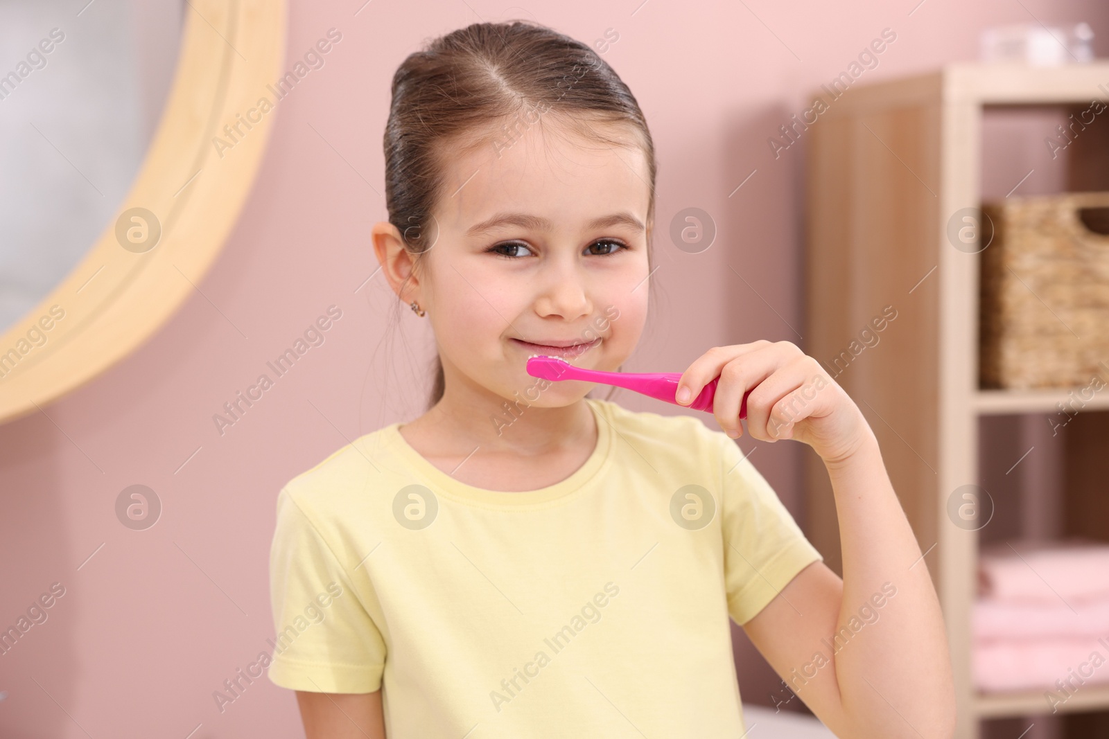 Photo of Cute girl brushing her teeth in bathroom