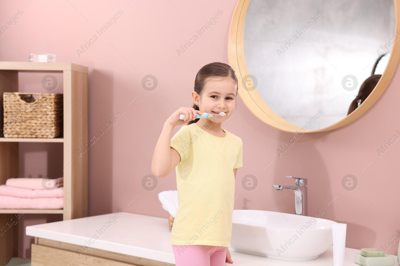 Photo of Cute girl brushing her teeth in bathroom