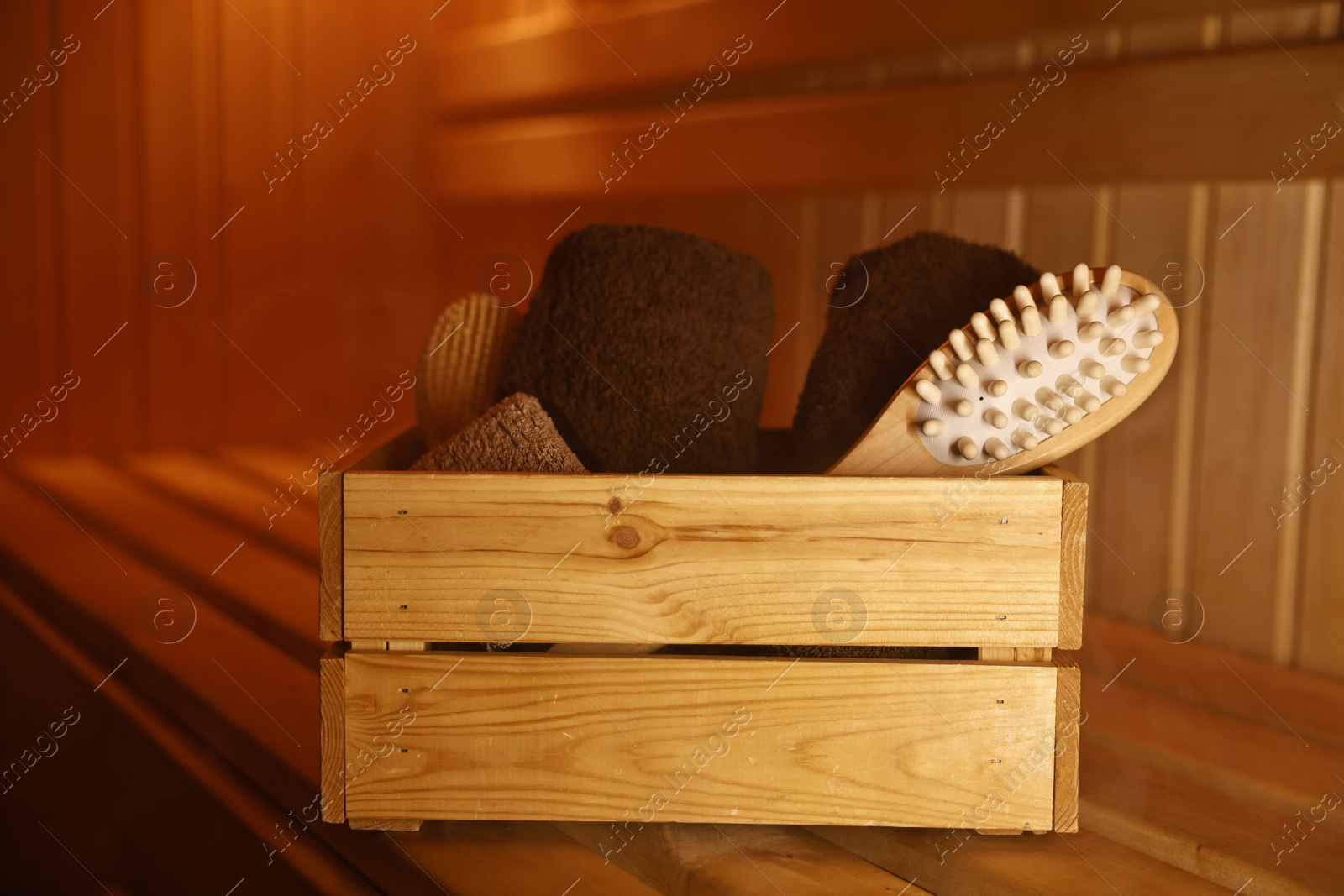 Photo of Crate with bath accessories on wooden bench in sauna