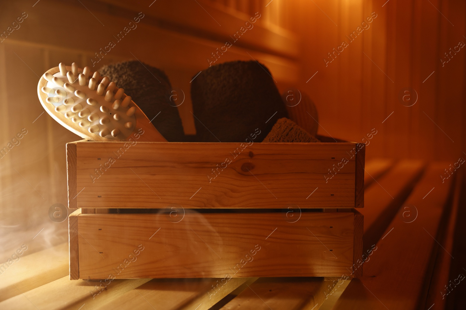 Photo of Crate with bath accessories on wooden bench in sauna