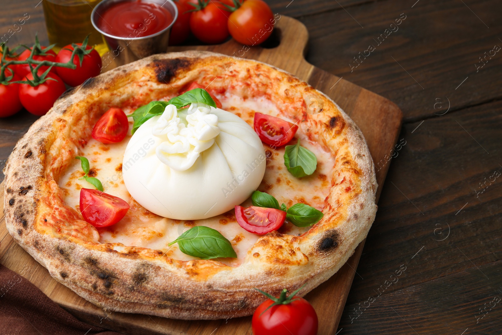 Photo of Delicious pizza with burrata cheese, basil, sauce and tomatoes on wooden table, closeup