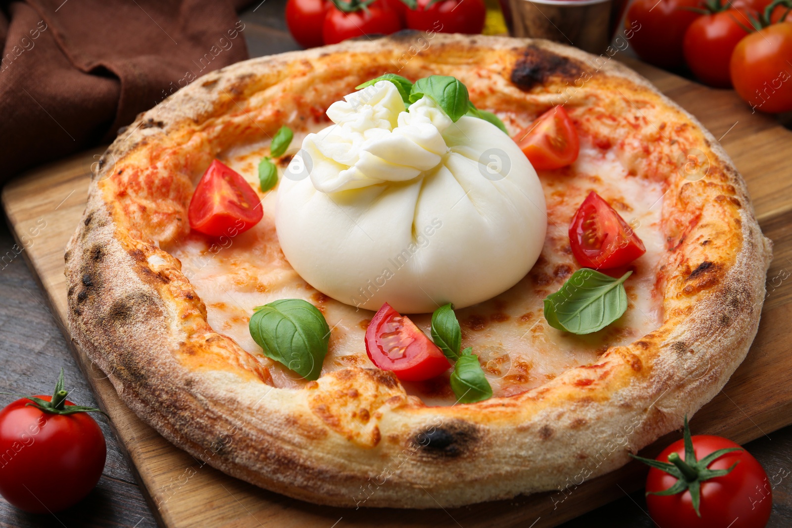 Photo of Delicious pizza with burrata cheese, basil and tomatoes on table, closeup