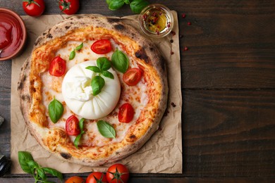 Photo of Delicious pizza with burrata cheese served on wooden table, top view. Space for text