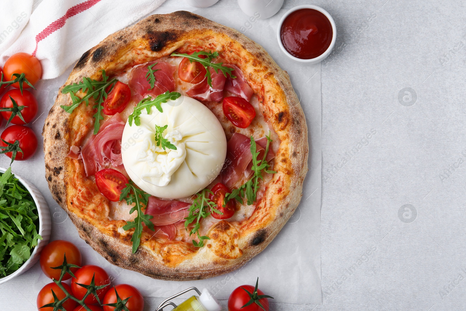 Photo of Delicious pizza with burrata cheese served on light grey table, top view. Space for text