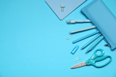Photo of Pencil case and different stationery on light blue background, flat lay. Space for text
