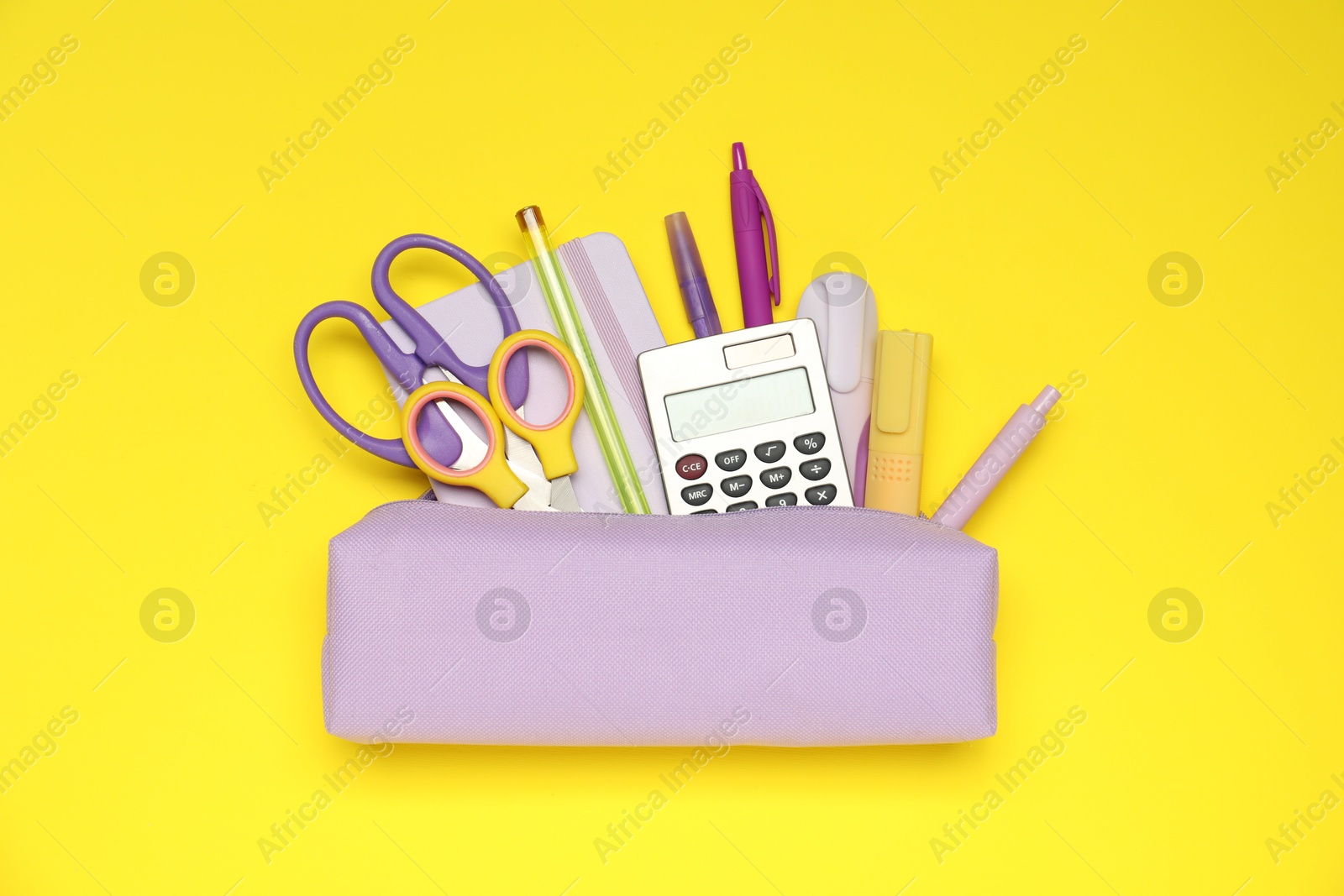 Pencil case and different stationery on yellow background, flat lay Photo of Pencil case and different stationery on yellow background, flat lay